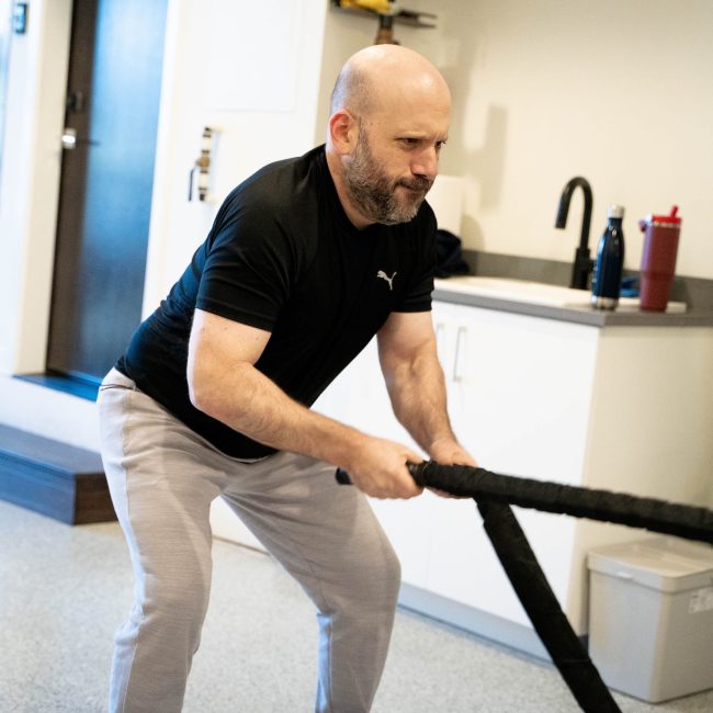 Male client performing a battle rope exercise during a personal training session in Portland.